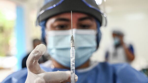 Медработник встряхивает шприц с вакциной от коронавируса, чтобы выгнать пузырьки воздуха  - Sputnik Қазақстан