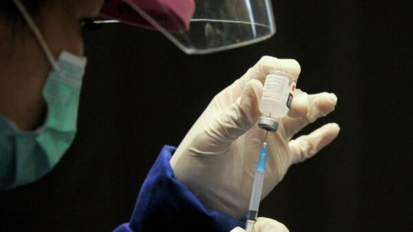 Медик в защитном костюме набирает в шприц вакцину от коронавируса  - Sputnik Казахстан