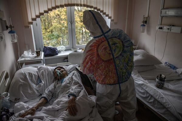 Волонтер ухаживает за больным коронавирусом пациентом Городской клинической больницы № 52 в Москве  - Sputnik Казахстан