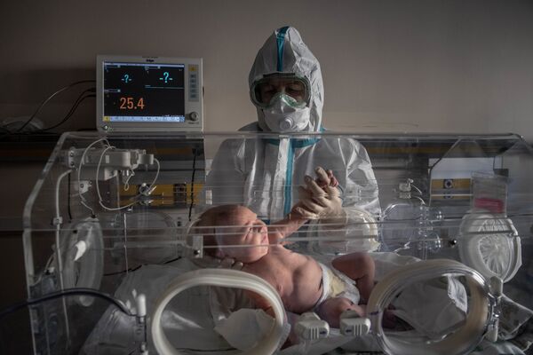 Медицинский работник и новорожденный ребенок в инфекционной больнице № 2 в Москве - Sputnik Қазақстан