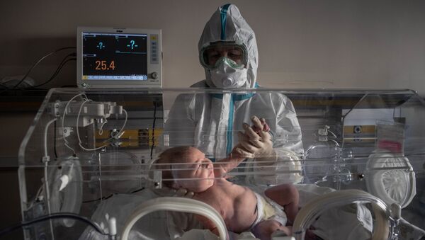 Медицинский работник и новорожденный ребенок в инфекционной больнице № 2 в Москве - Sputnik Казахстан