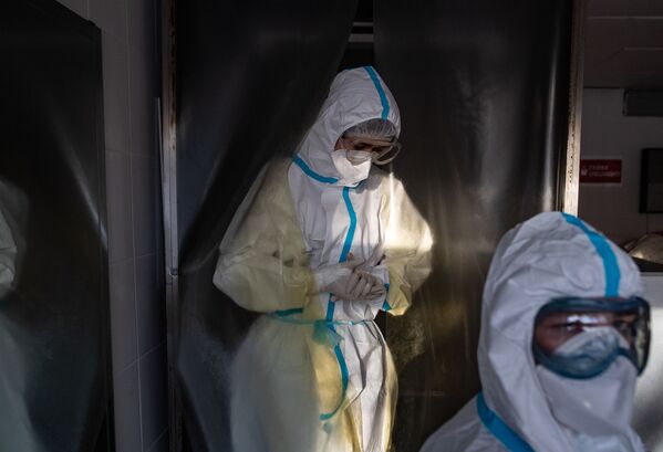 Медик, одетый в СИЗ, проходит через дезинфекционную камеру Московской городской клинической больницы № 15 (больница имени Филатова) - Sputnik Казахстан
