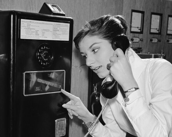 Немецкая девушка во время использования телефона с междугородной связью, 1957 год  - Sputnik Казахстан