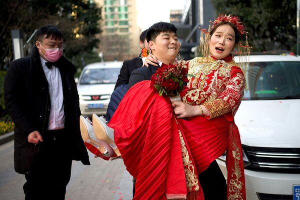 Жених несет невесту в отель после свадьбы в Ухане, Китай - Sputnik Казахстан