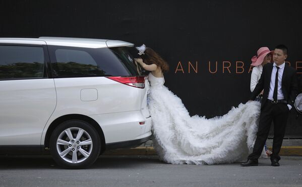 Невеста отдыхает в тени во время свадебной фотосессии в Шанхае    - Sputnik Қазақстан