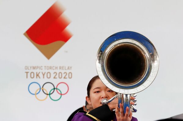 Участник оркестра  играет на музыкальном инструменте во время эстафеты Олимпийского огня в Токио-2020 в префектуре Фукусима, Япония - Sputnik Казахстан