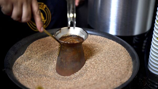 Мексиканский бариста готовит фирменный турецкий кофе в медном горшочке на горячем песке, Мехико - Sputnik Казахстан