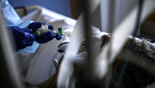 Медик подключает пациента в палате интенсивной терапии к аппарату искусственной вентиляции легких в больнице с коронавирусом  - Sputnik Казахстан