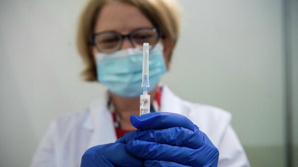 Врач подготовила шприц с вакциной от коронавируса для прививки пациента - Sputnik Казахстан