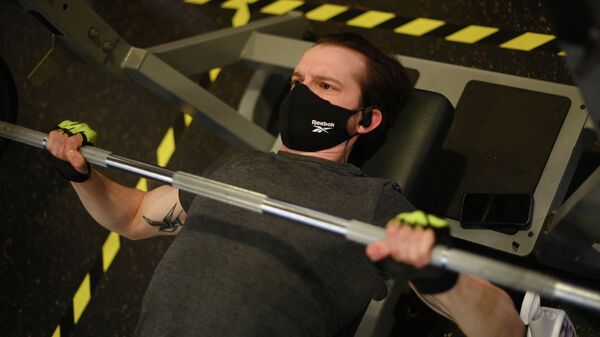 Мужчина в защитной маске занимается в фитнес-зале  - Sputnik Казахстан