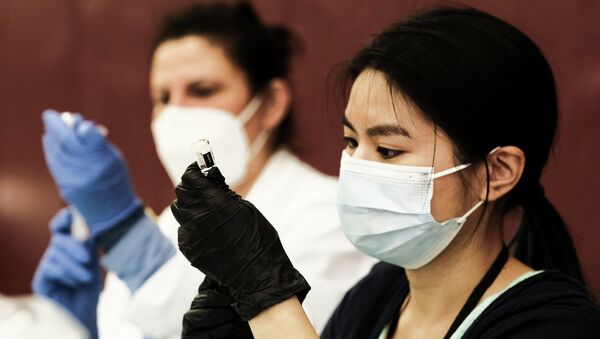 Сотрудники центра массовой вакцинации против коронавируса в масках готовят инъекции - Sputnik Казахстан