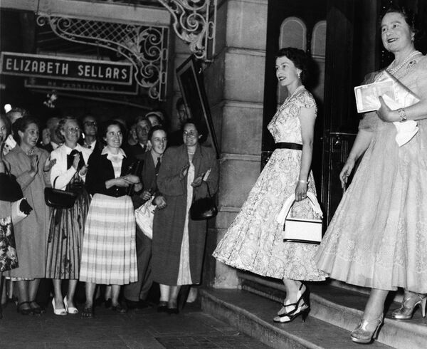 Прохожие аплодируют королеве Елизавете II и ее матери, королеве Елизавете, когда они покидают новый театр в Лондоне, Англия, 4 августа 1955 года, после просмотра спектакля &quot;Выдающийся мистер Пеннипакер&quot;. Королева-мать отпраздновала свое 55-летие. - Sputnik Казахстан