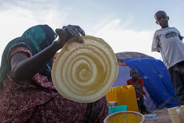Сомалийская женщина во время приготовления блинов в Могадишо  - Sputnik Қазақстан