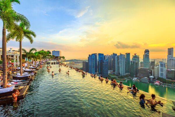  Пейзажный бассейн на закате в Skypark, который возвышается над отелем Marina Bay Sands в Сингапуре  - Sputnik Казахстан