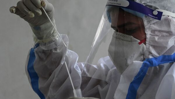 Медик в защитном костюме готовит набор для ПЦР-теста на коронавирус - Sputnik Қазақстан