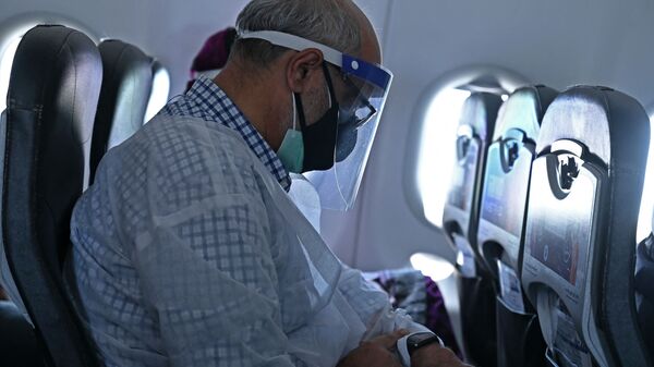 Мужчина в защитной маске в салоне самолета  - Sputnik Казахстан