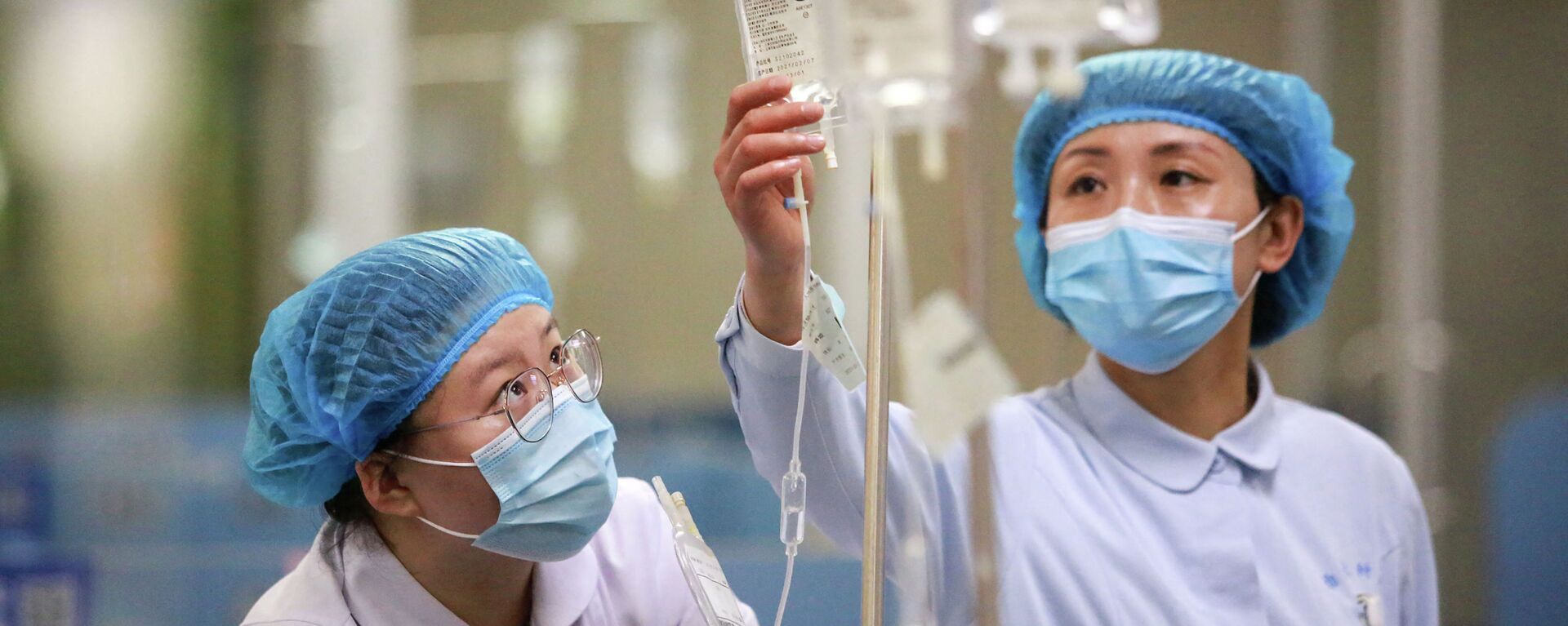 Медсестры в защитных костюмах поправляют капельницы в больнице с коронавирусом - Sputnik Қазақстан, 1920, 28.07.2021