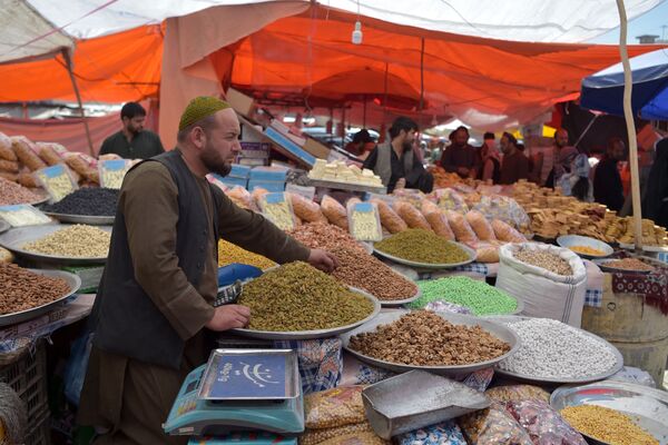 Продавец ждет покупателей у своего ларька с сухофруктами и печеньем в преддверии праздника Ид аль-Фитр на рынке в Кабуле - Sputnik Қазақстан