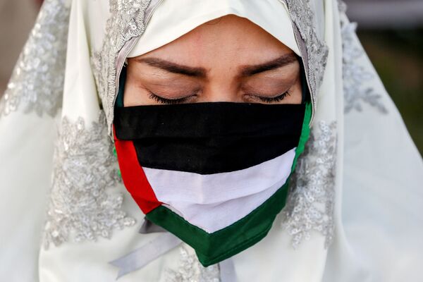 Мусульманка в маске в виде палестинского флага во время молитвы в Великой мечети Аль-Азхар во время праздника Ид аль-Фитр в Джакарте, Индонезия - Sputnik Қазақстан
