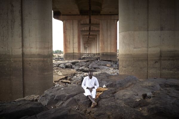  Мужчина медитирует под третьим мостом Бамако во время Ид-аль-Фитр - Sputnik Казахстан