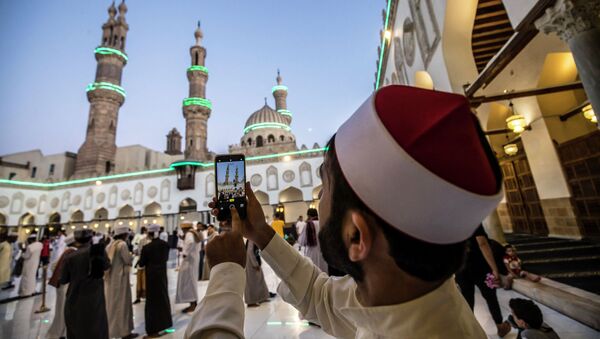 Мусульманин фотографирует праздничную подсветку минаретов церкви перед началом массовой молитвы после завершения священного месяца Рамазан - Sputnik Казахстан