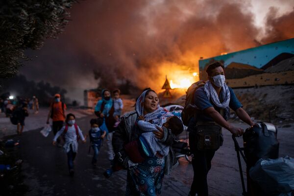 Снимок из серии Fleeing a Fire Burning Refugee Camp греческого фотографа Petrosa Giannakouris, ставшим третьим в категории Single News конкурса Istanbul Photo Awards 2021 - Sputnik Қазақстан