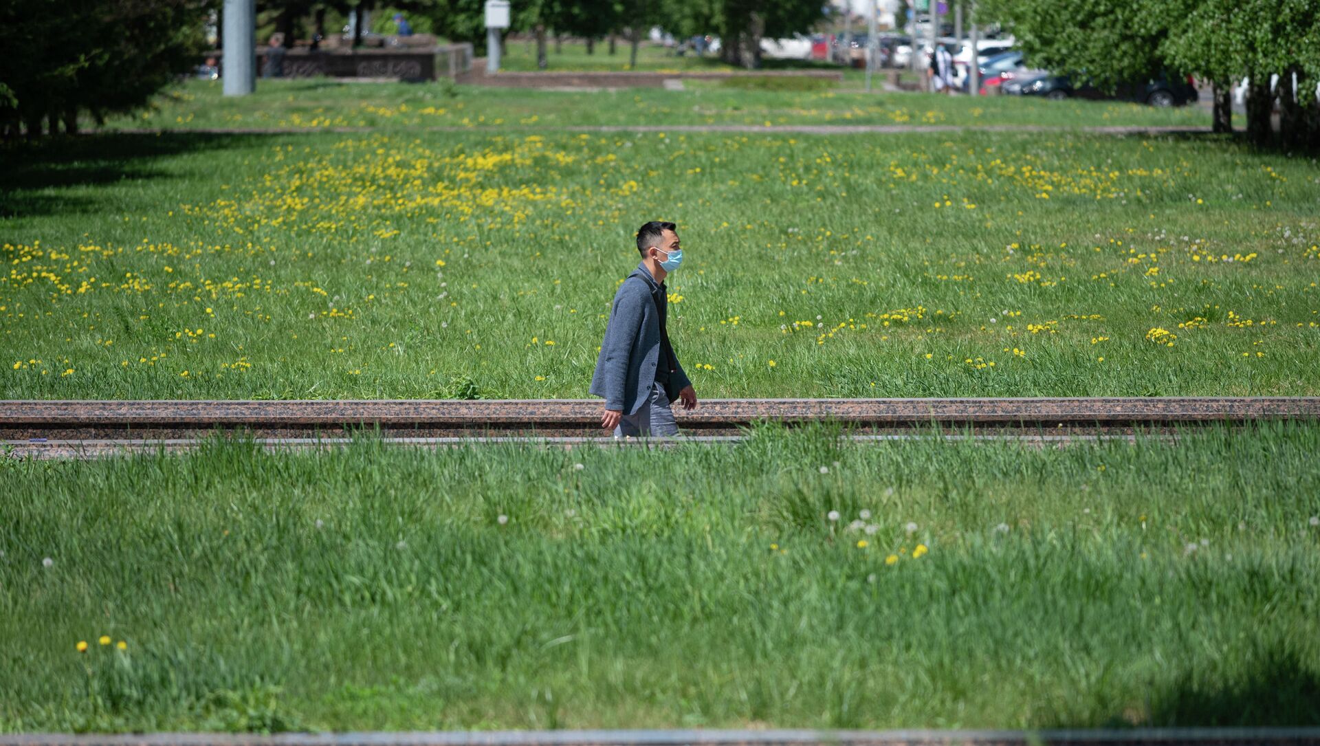 Мужчина в маске идет по дорожке между газонами в Нур-Султане - Sputnik Қазақстан, 1920, 21.05.2021