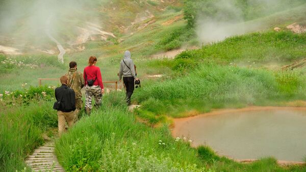 Туристы проходят около Утиных озер в Долине Гейзеров в Кроноцком государственном природном биосферномй заповеднике на Камчатке - Sputnik Қазақстан