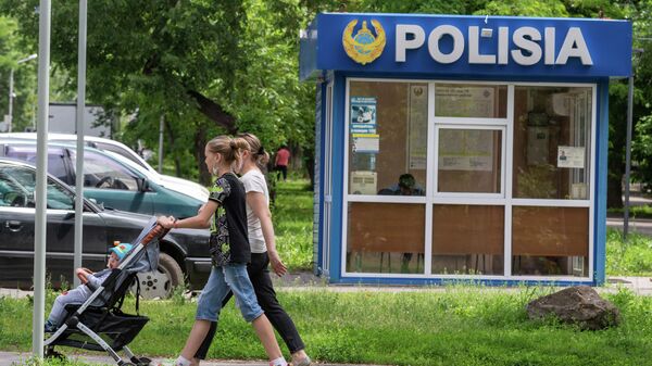 Женщины с коляской проходят мимо полицейского пункта - Sputnik Қазақстан