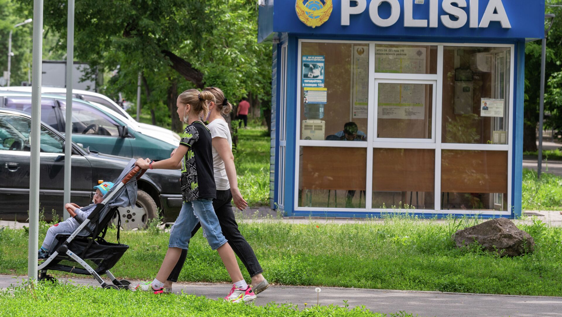 Женщины с коляской проходят мимо полицейского пункта - Sputnik Қазақстан, 1920, 17.06.2021