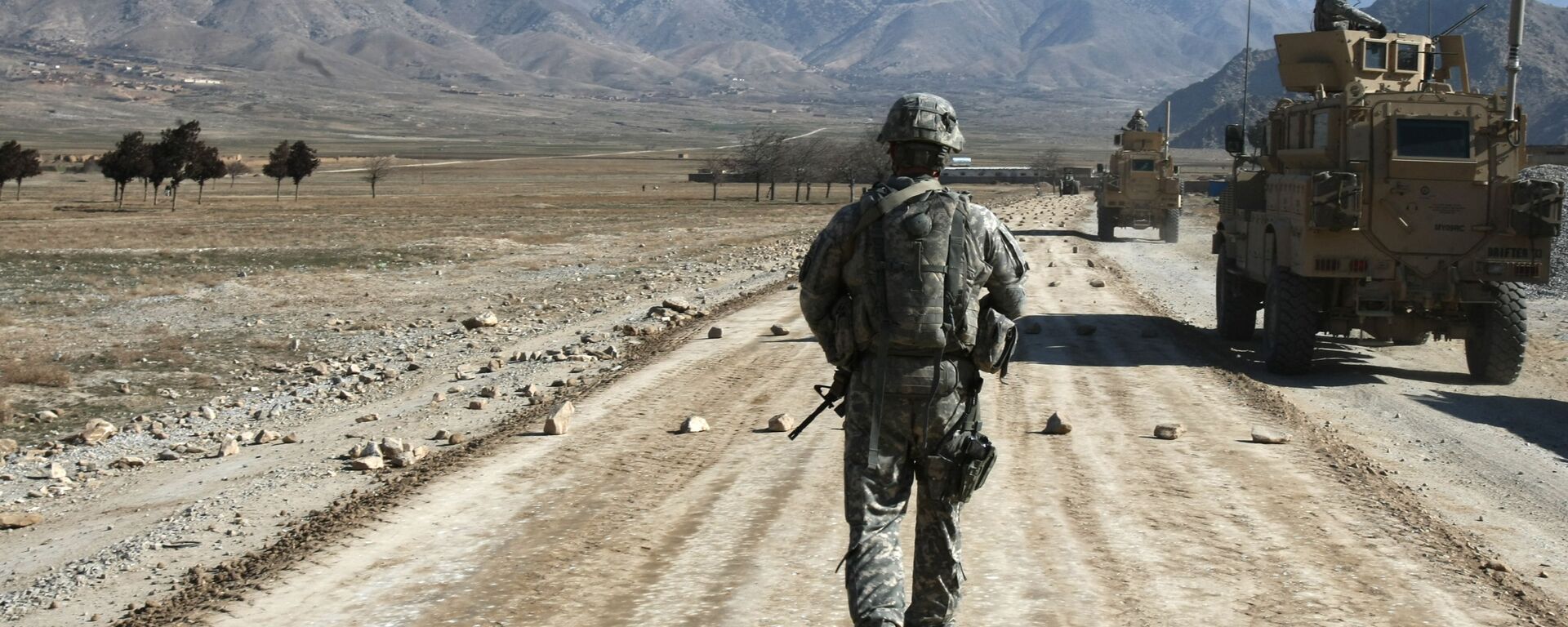Американский солдат идет по строящейся дороге возле Баграма, примерно в 60 км от Кабула, Афганистан - Sputnik Қазақстан, 1920, 08.07.2021
