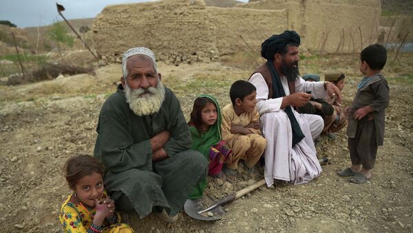 Мужчины и дети сидят перед своим домом. В центре территории, осажденной талибами, одна из самых важных плотин гидроэлектростанций Афганистана - Sputnik Казахстан