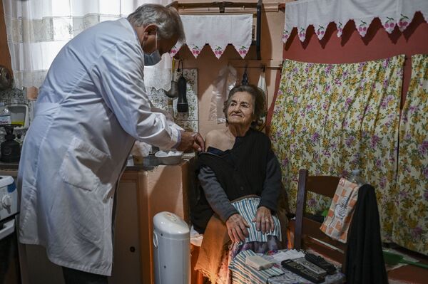 Доктор Анаргирос Мариолис вакцинирует пожилую женщину от Covid-19 на острове Элафониссос - Sputnik Казахстан