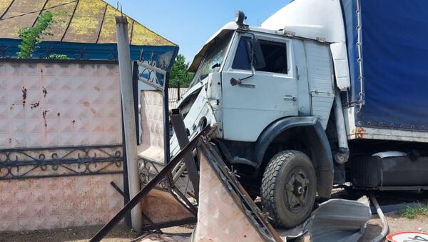 КамАЗ после столкновения с легковушкой повредил газовую трубу и снес ворота частного дома на улице Папаина  - Sputnik Казахстан