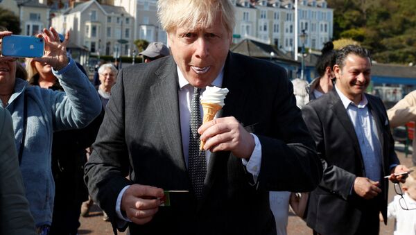  Премьер-министр Великобритании Борис Джонсон во время поедания мороженого в Северном Уэльсе  - Sputnik Казахстан