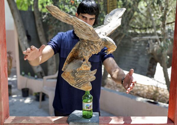 Палестинец во время балансировки скульптуры на бутылке в городе Бейт-Лахия - Sputnik Қазақстан