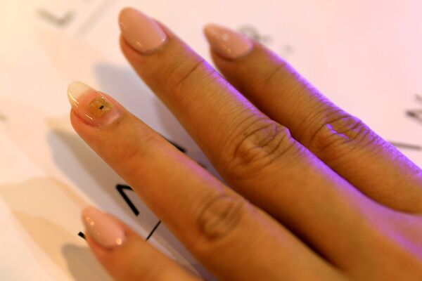 Процесс вживления микрочипа с личными данными в ноготь клиентки салона красоты Lanour Beauty Lounge в Дубае, ОАЭ - Sputnik Қазақстан