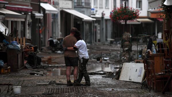 Пара обнимаются, стоя среди обломков, в городе Бад-Нойенар-Арвайлер, Германия  - Sputnik Қазақстан