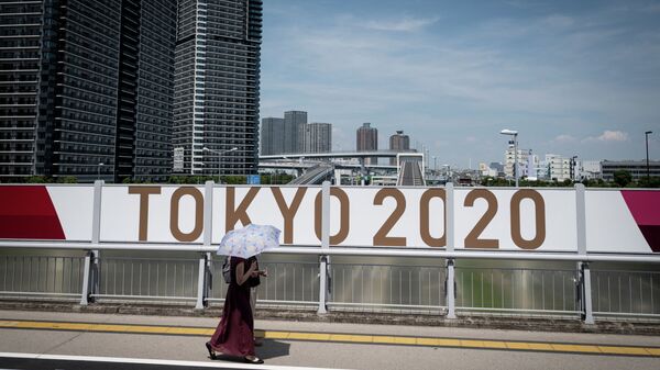 Женщина проходит неподалеку от Олимпийской деревни в Токио - Sputnik Қазақстан