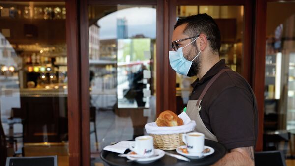 Официант в маске несет заказ посетителям кафе - Sputnik Казахстан