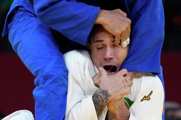 Бразильский дзюдоист Даниэль Каргнин пытается сопротивляться удушающему приему соперника Мохамеда Абдельмагуда из Египта на Олимпиаде - Sputnik Казахстан