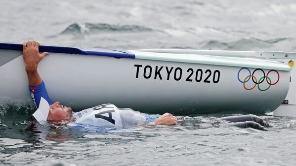 Факундо Олецца из Аргентины плывет за бортом своей лодки после соревнований по парусному спорту на Олимпиаде - Sputnik Казахстан