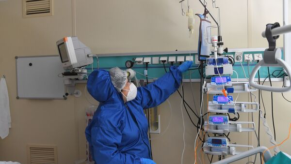 Медсестра в защитном костюме работает с аппаратурой в реанимации больницы с коронавирусом  - Sputnik Қазақстан