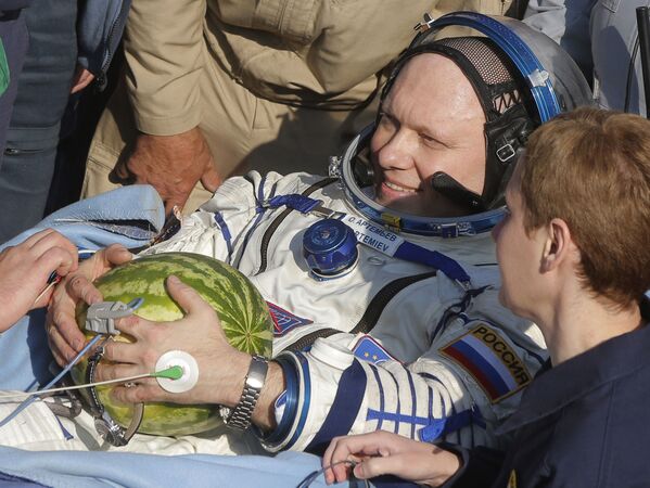 Российский космонавт Олег  Артемьев с арбузом после возвращения на Землю в Казахстане  - Sputnik Қазақстан
