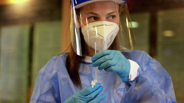 Медик в защитном костюме готовится взять пробу для ПЦР-анализа на коронавирус - Sputnik Казахстан
