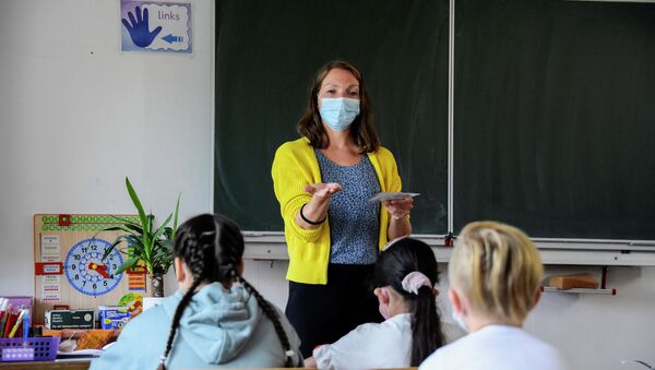 Учительница в маске беседует с детьми на уроке в школе  - Sputnik Казахстан