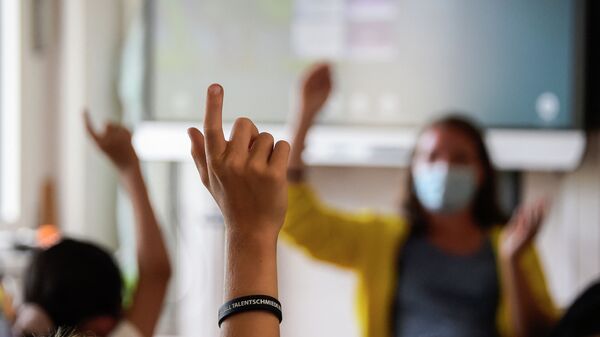 Ученики на уроке поднимают руки, чтобы ответить учителю - Sputnik Казахстан