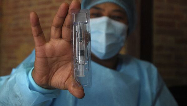 Медицинский работник показывает предварительно заполненный шприц вакцины Vero Cell Covid-19 китайского производства - Sputnik Казахстан