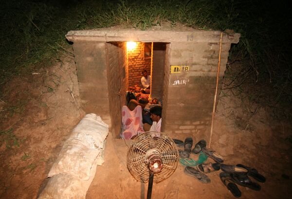 Люди прячутся в бомбоубежище в на границе Индии и Пакистана. - Sputnik Казахстан