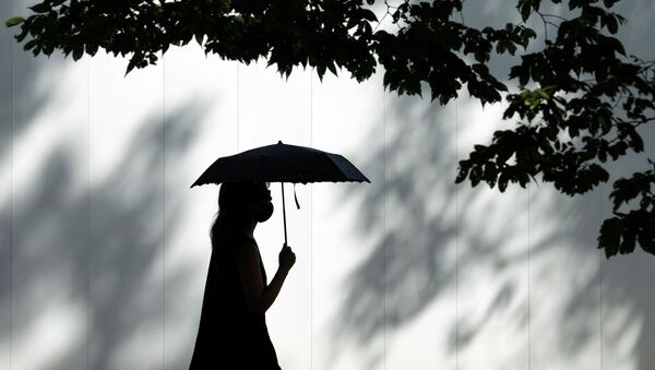 Девушка в маске идет под зонтом по улице - Sputnik Казахстан